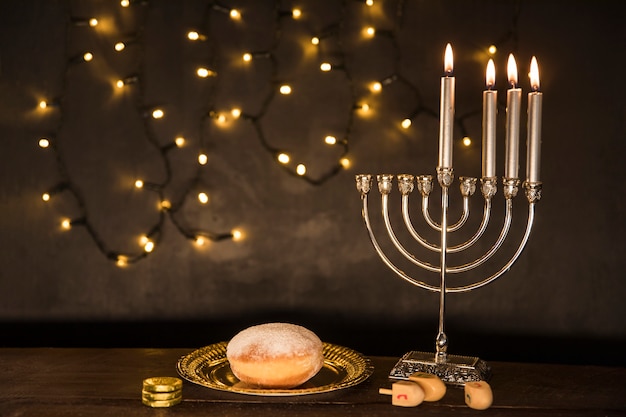 Gelt en dreidels die dichtbij doughnut en menorah liggen