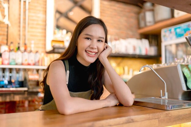 Geluk vrolijke Aziatische vrouwelijke vrouw in uniform klein bedrijf coffeeshop Azië vrouw eigenaar werken in coffeeshop Chinese vrouwelijke barista koffie maken met koffiezetapparaat in de café winkel winkel