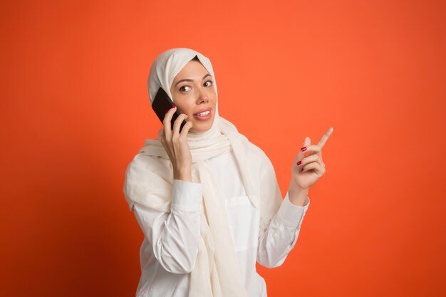 Gelukkig Arabische vrouw in hijab met mobiele telefoon.