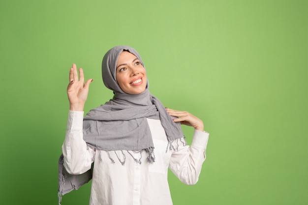 Gelukkig Arabische vrouw in hijab. Portret dat van glimlachend meisje, bij groene studio stelt.