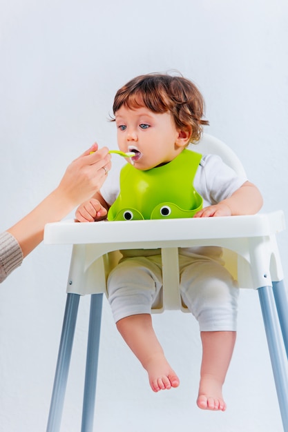 Gelukkig babyjongen zitten en eten