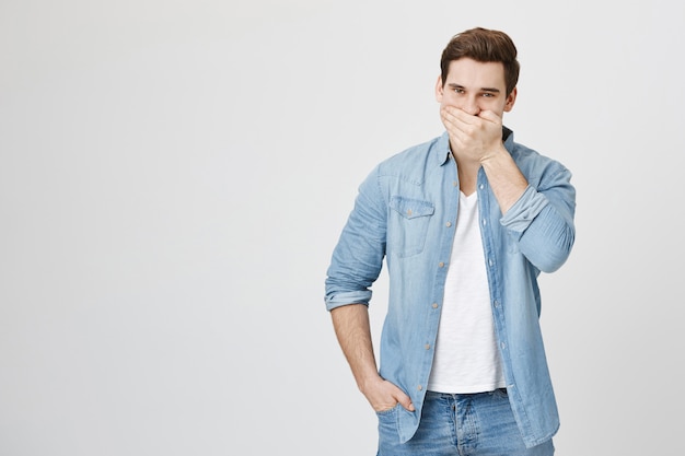 Gelukkig blanke man lachen, bedek de mond terwijl grinniken