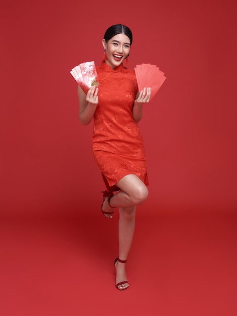 Gelukkig Chinees nieuwjaar Aziatische vrouw die traditionele cheongsam qipao-jurk draagt met angpao