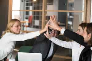 Gratis foto gelukkig commercieel team die high-five samen geven die belofte en loyaliteit beloven