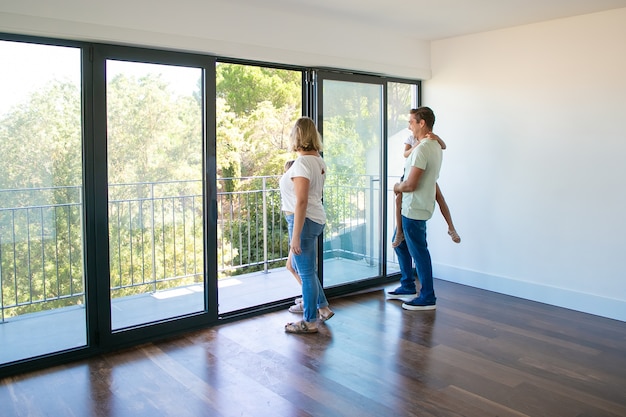 Gelukkig gezin met kinderen balkon kijken en glimlachen