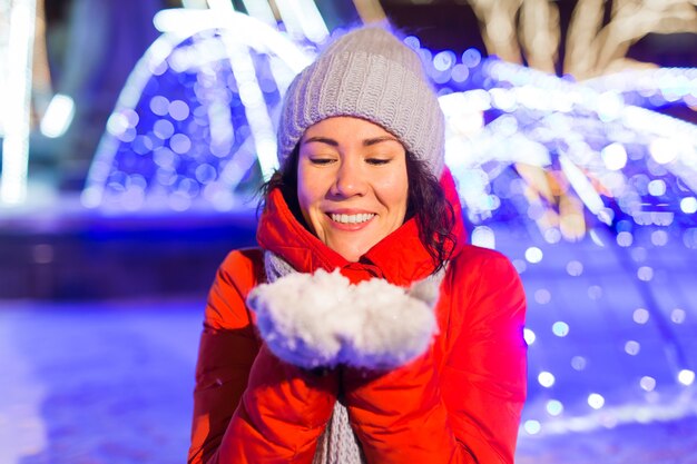 Gelukkig grappige jonge vrouw met winterkleren achtergrond avond stadslichten verlichting. kerst en winter vakantie concept.