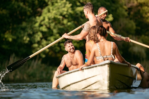 Gratis foto gelukkig groep vrienden met plezier, lachen en zwemmen in de rivier