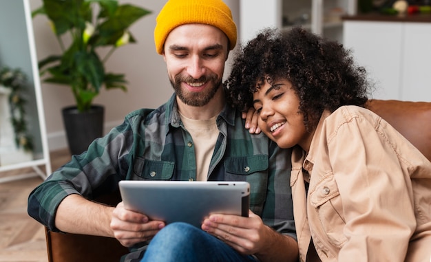 Gelukkig hipsterpaar dat op tablet kijkt