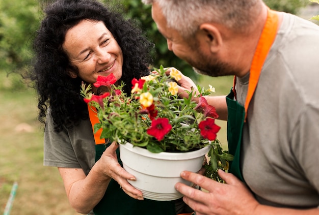 Gratis foto gelukkig hoger paar met bloemen