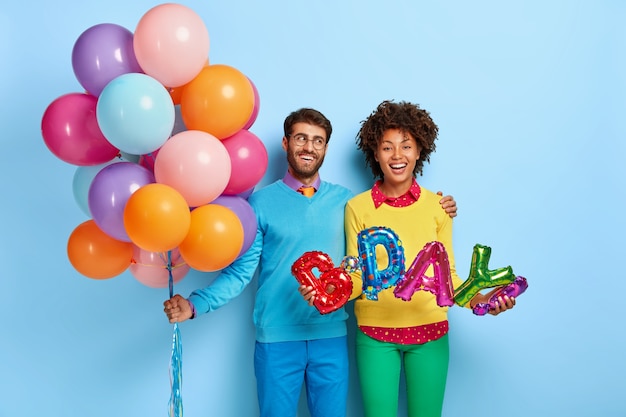 Gelukkig jong koppel op een feestje poseren met ballonnen