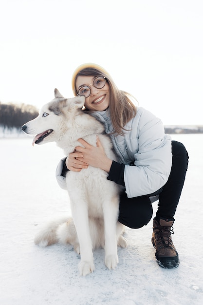 Gelukkig jong meisje spelen met Siberische husky hond in winter park