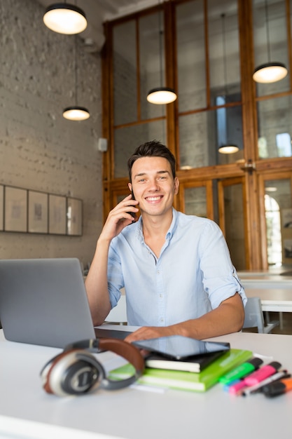 Gelukkig jonge knappe man zit in co-working office