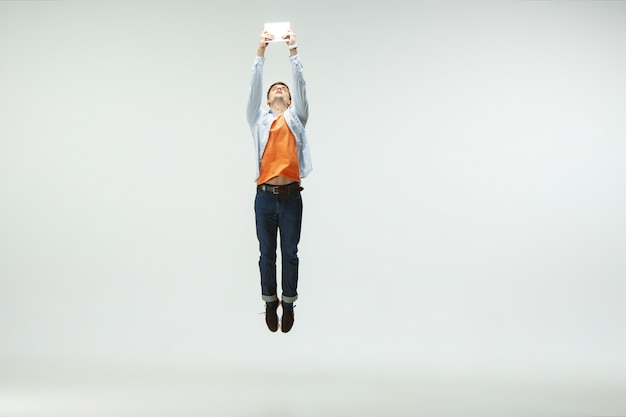 Gelukkig jonge man aan het werk op kantoor, springen en dansen in vrijetijdskleding of pak geïsoleerd op een witte achtergrond.