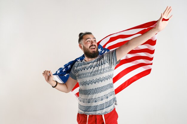 Gelukkig jonge man met vlag van de Verenigde Staten van Amerika geïsoleerd op witte studio.