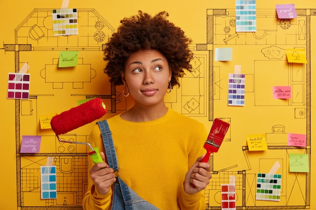 Gratis foto gelukkig jonge vrouw ontwerper planning renovatie van modern appartement