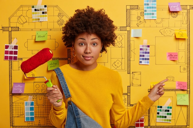 Gelukkig jonge vrouw ontwerper planning renovatie van modern appartement