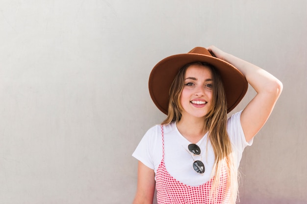 Gratis foto gelukkig jonge vrouw poseren met hoed