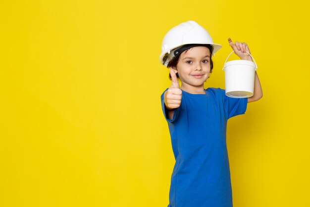 gelukkig kind glimlachend schattig schattig bedrijf verven in blauw t-shirt op gele muur