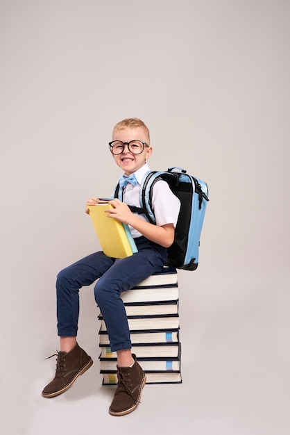 Gelukkig kind met rugzak en stapel boeken