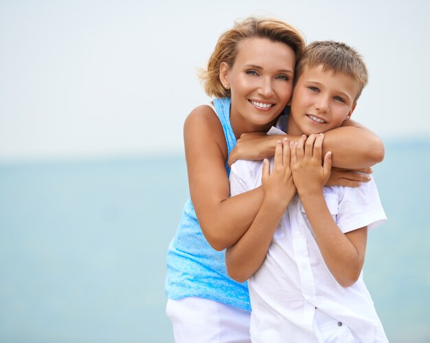 Gelukkig lachend moeder en zoon plezier op het strand.