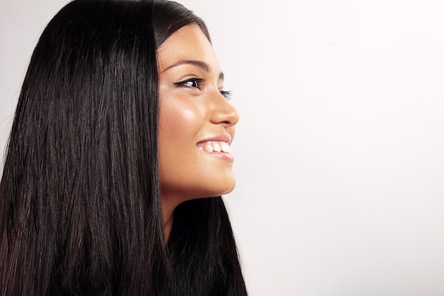 Gratis foto gelukkig lachend vrouwenprofiel met steil haar in studio