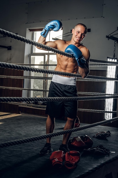 Gelukkig lachende man staat op de ring na kickboksen sparren.