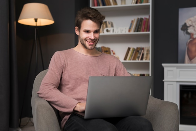 Gratis foto gelukkig man kijkt naar laptop