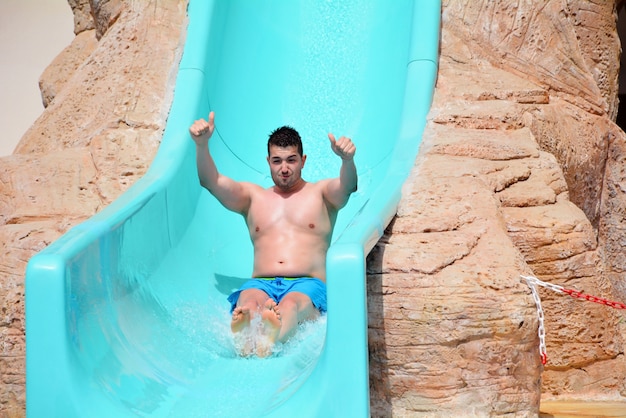 Gelukkig man op de glijbaan in het waterpark