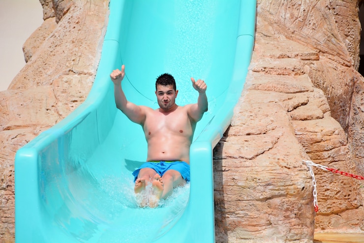 Gratis Foto gelukkig man op de glijbaan in het waterpark