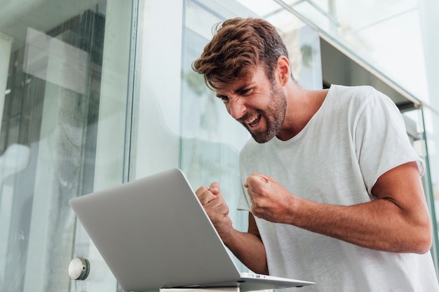 Gelukkig man vieren met laptop