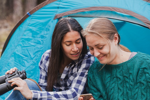 Gelukkig meisje dat haar mobiele telefoon aan haar vriend