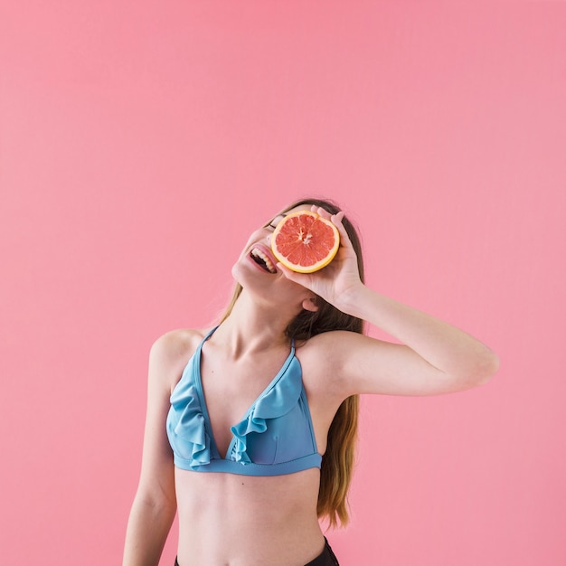 Gratis foto gelukkig meisje in bikini met grapefruit