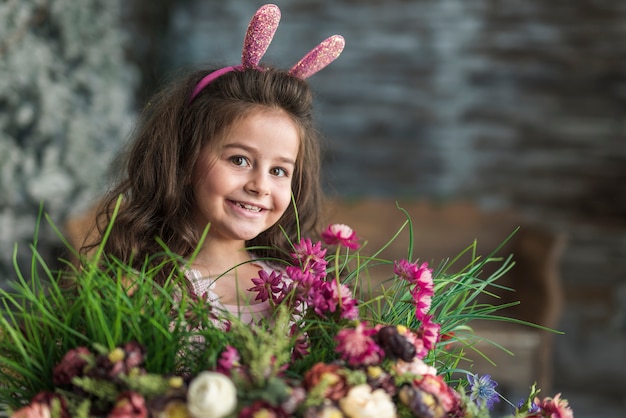Gelukkig meisje in konijntjesoren met bloemen