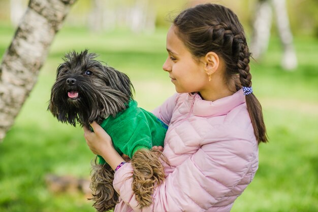 Gelukkig meisje knuffelen haar hond buitenshuis