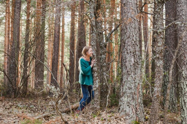 Gelukkig meisje verbergen naast een boom