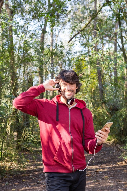 Gelukkig mens met sportkleding bedrijf zijn mobiele telefoon