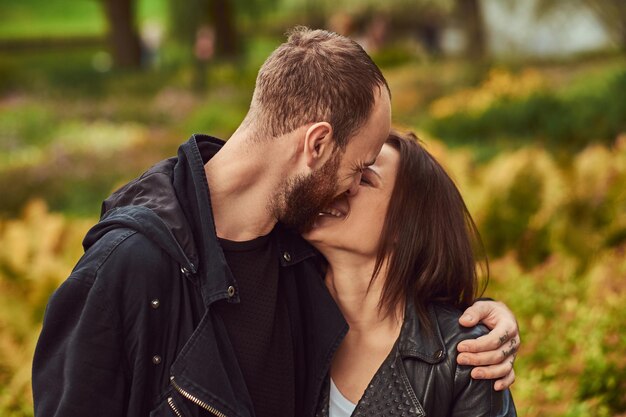 Gelukkig modern paar in het park. Genieten van hun liefde en de natuur.