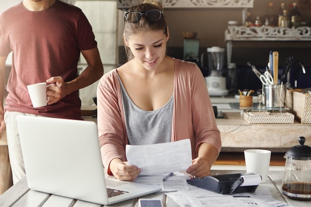 Gratis foto gelukkig mooie vrouw bericht van de bank lezen over verlenging van de hypotheektermijn