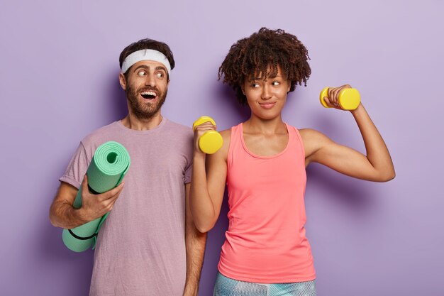 Gelukkig multi-etnisch paar sporten succes, hebben training in de sportschool met halters