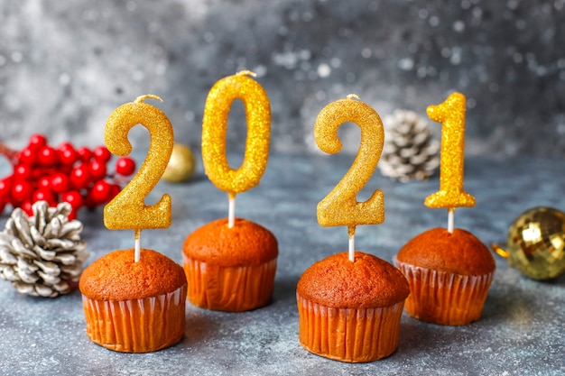 Gelukkig nieuwjaar 2021, cupcakes met gouden kaarsen.