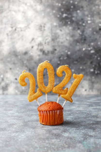 Gelukkig nieuwjaar 2021, cupcakes met gouden kaarsen.