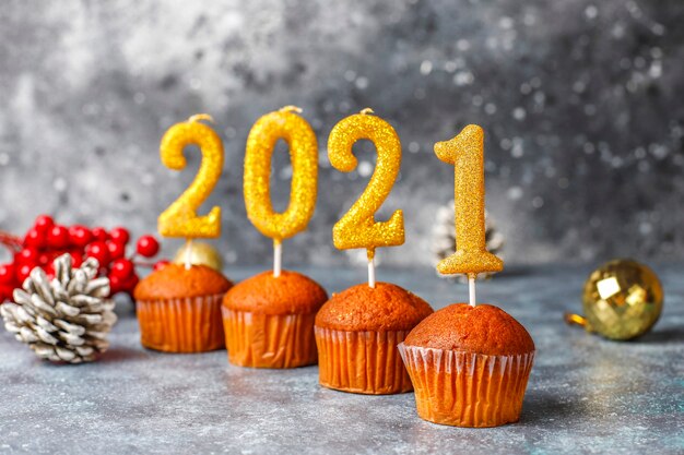 Gelukkig nieuwjaar 2021, cupcakes met gouden kaarsen.