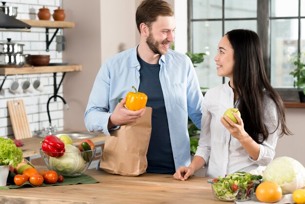 Gelukkig paar dat zich in keuken bevindt die elkaar in keuken bekijkt