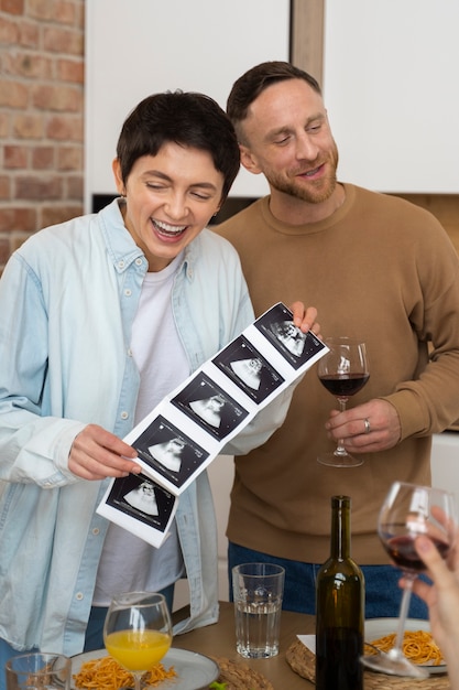 Gratis foto gelukkig paar dat zwangerschap aankondigt tijdens diner met vrienden