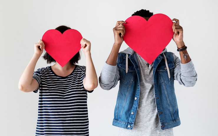 Gratis Foto gelukkig paar die rode hartpictogrammen houden