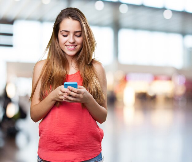 gelukkig schattige jonge vrouw het typen van een tekst op mobiele op wit