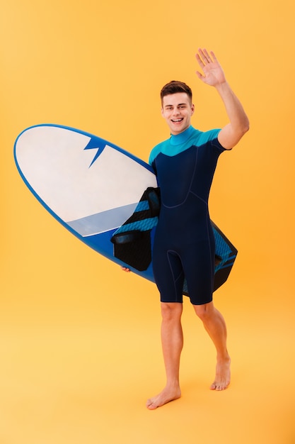 gelukkig surfer wandelen met surfboard