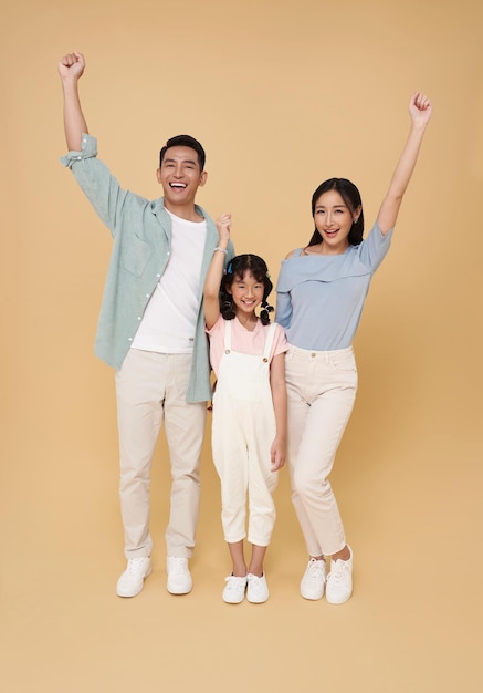 Gelukkig vieren Aziatische ouder familie portret staan met handen omhoog