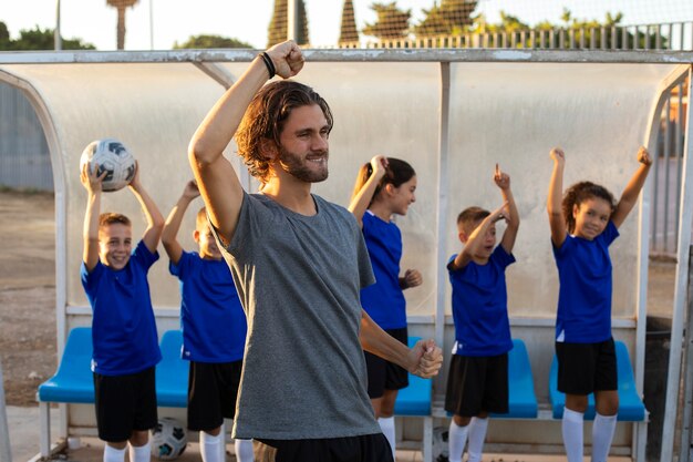 Gelukkig voetbaltrainer zijaanzicht