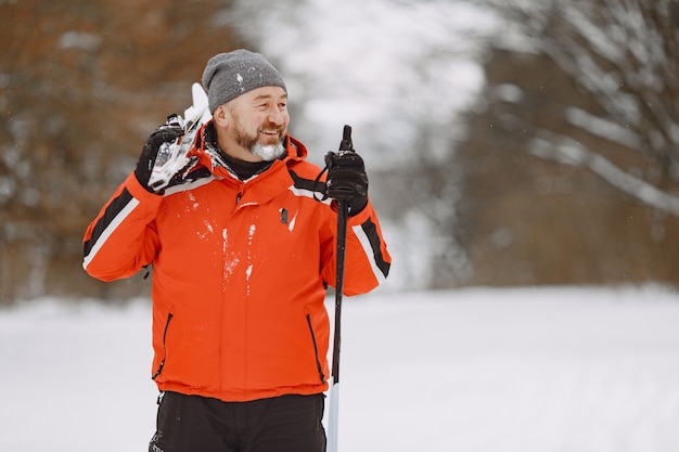 Gelukkig volwassen man in winter park. senior activewear trekking in het bos ter vrije besteding